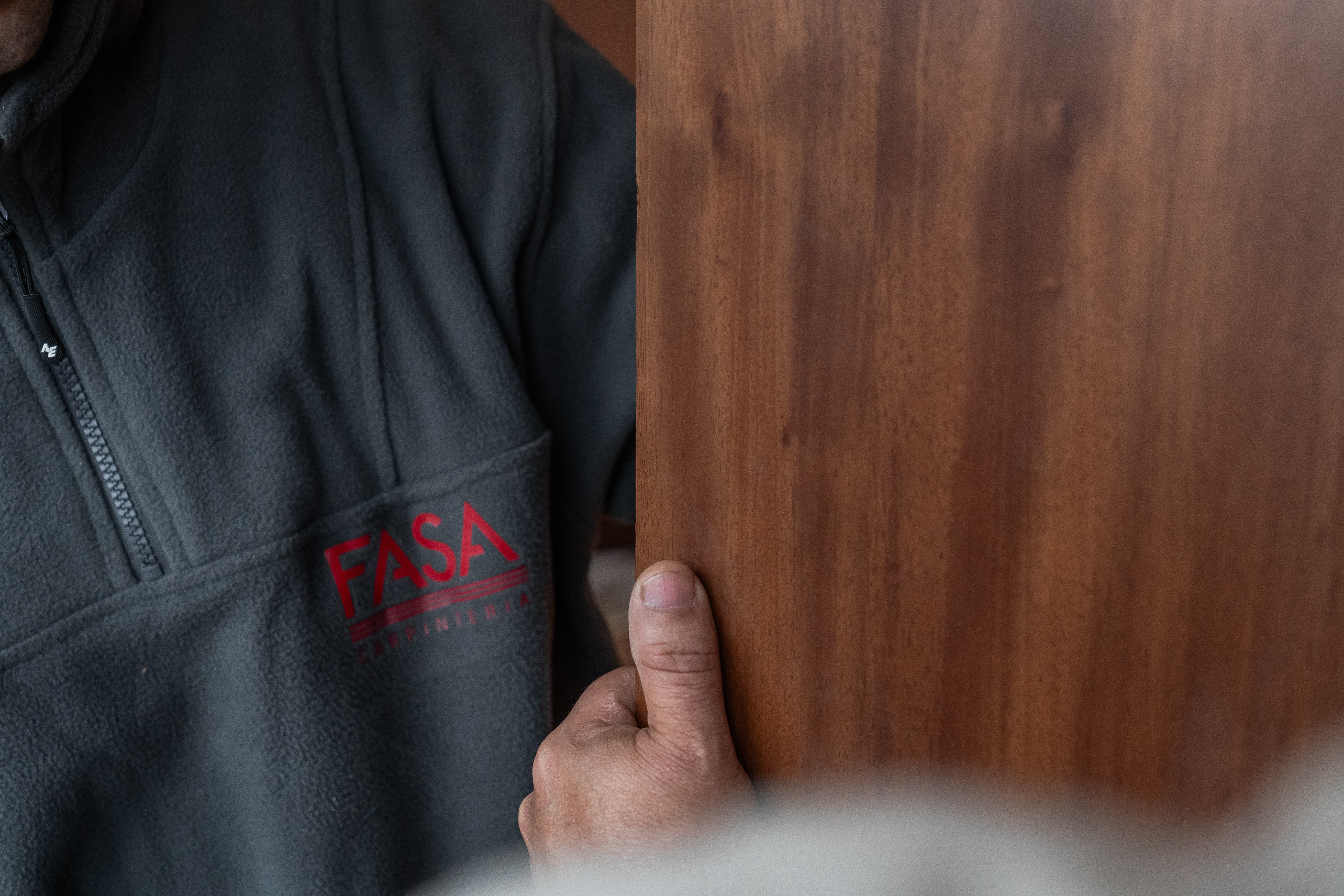 Carpintero de FASA con el logo de la marca, trabajando una pieza de madera